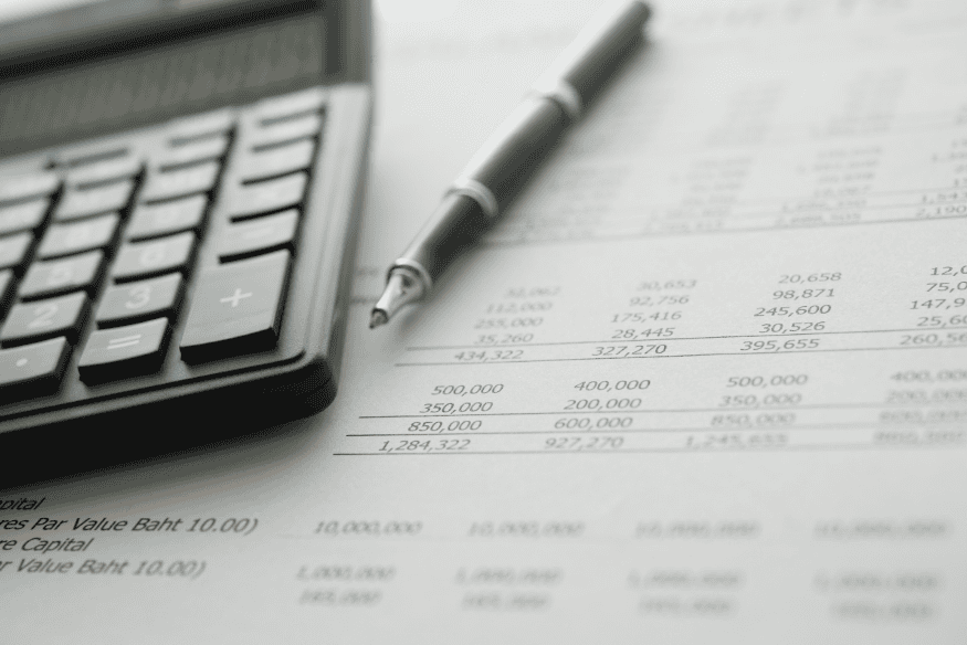 Calculator and pen on a financial statement comparing cash and accrual accounting