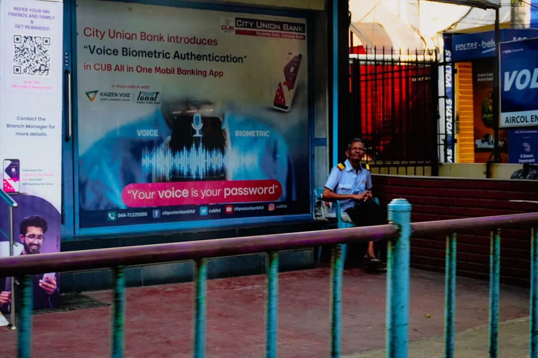 Man sitting at a bus stop with advertisement