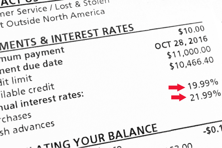 Close-up of a credit card statement highlighting high annual interest rates and balances.