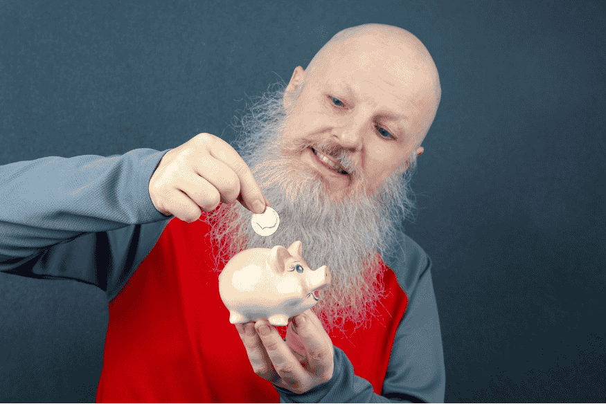 Man putting a coin into a small piggy bank to build long-term savings