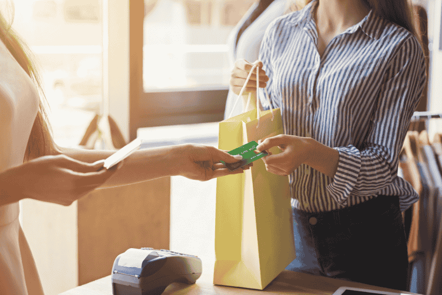 Customer paying with a card at a store while managing a big purchase responsibly.