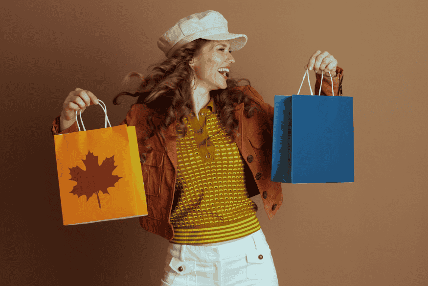 Happy woman holding shopping bags after planning a big purchase without using debt.