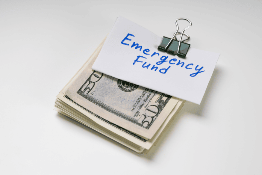 Stack of US dollars clipped with a note labeled emergency fund for business emergencies