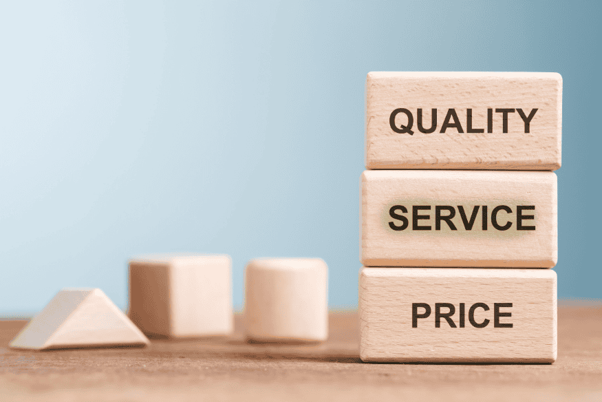 Wooden blocks labeled quality, service and price illustrating how freelancers balance value and pricing strategy.