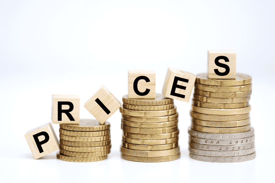 Stacks of coins spelling prices to show how thoughtful pricing helps freelancers reach personal financial goals.