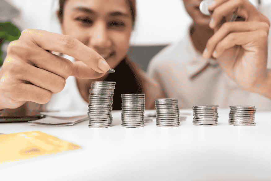 Couple counting coins and organizing savings to build realistic financial goals together.