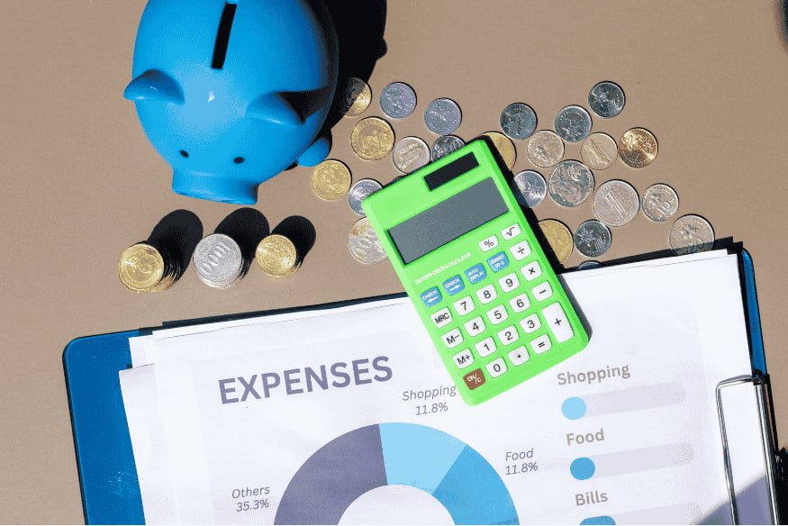 Blue piggy bank, coins, calculator and printed expense report on a clipboard, symbolizing organized expense tracking and savings planning.