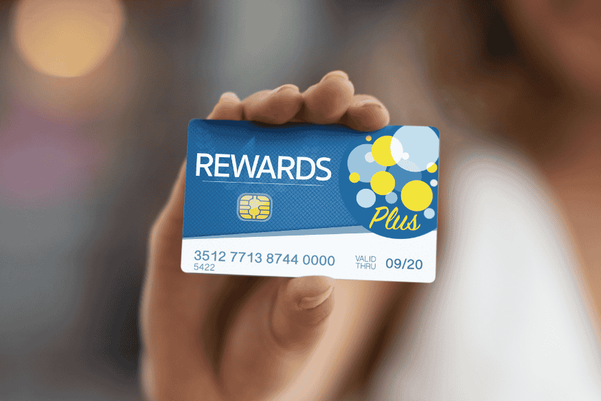 Person holding a rewards credit card highlighting premium card perks and bonuses.