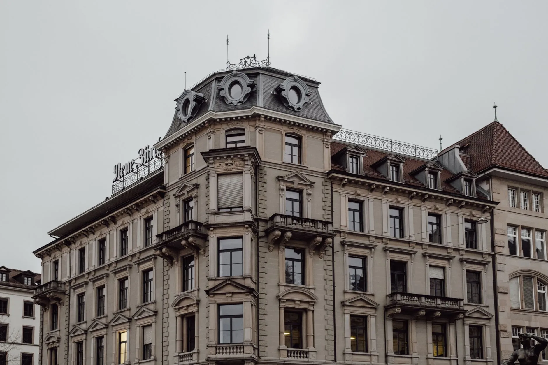 View of a neoclassical building in Zurich, showcasing urban architecture on a cloudy day.