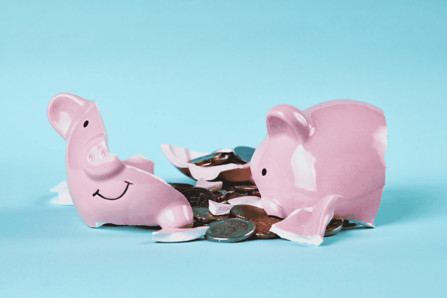 Broken piggy bank with coins spilled, representing common financial mistakes in your 20s.