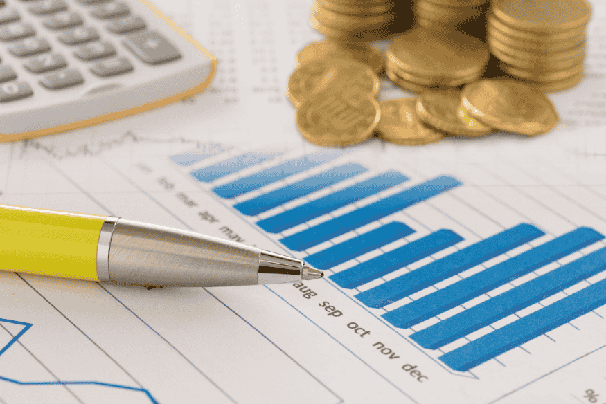 Pen, stacked coins and bar chart showing progress in a personal financial planning strategy